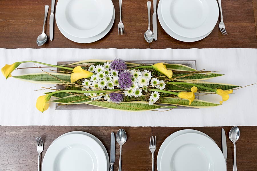 Jarní sváteční tabule s kalou, okrasným česnekem a chryzantémou