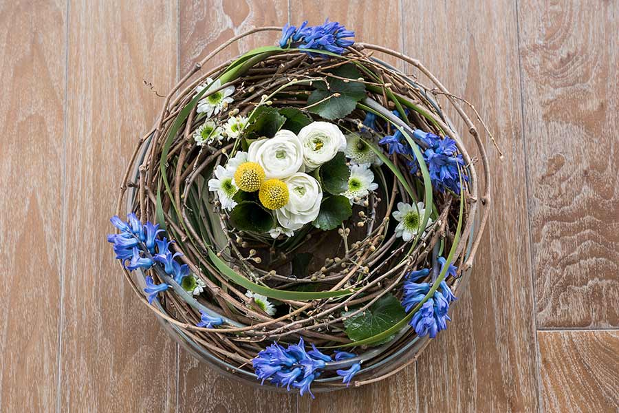 Jarní dekorace v míse s hyacintem, pryskyřníkem a kraspédií